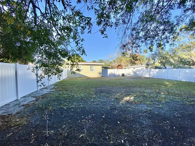 a view of a yard with plants and a tree