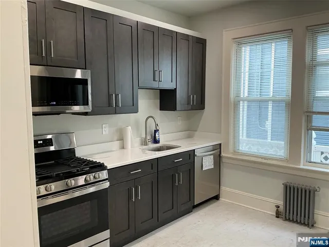 a kitchen with wooden cabinets and a stove top oven