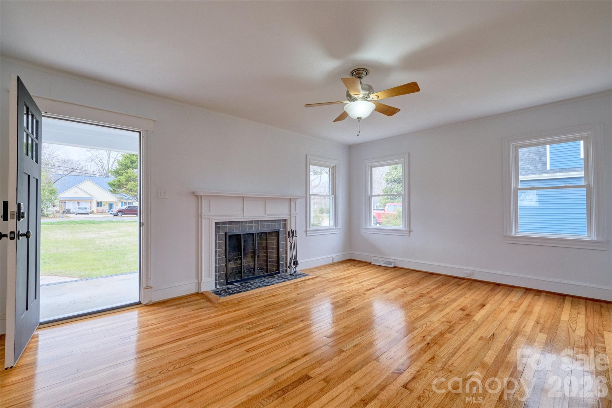 804 Congress Street North York, SC 29745 - Photo 3 of 48 an empty room with windows fireplace and a ceiling fan