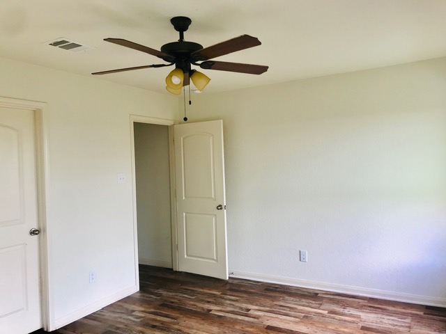 20105 Grover Cleveland Way Manor, TX 78653 - Photo 5 of 17 Well-lit room featuring laminate flooring and a stylish ceiling fan with integrated lighting.