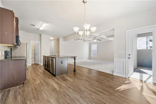 a view of a kitchen with a sink wooden floor and a chandelier