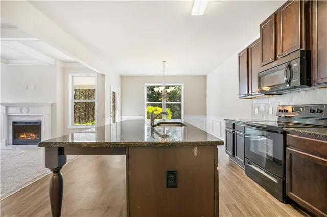 a kitchen with stainless steel appliances granite countertop a sink stove and microwave