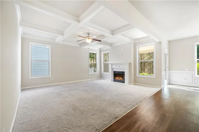 an empty room with windows and fireplace