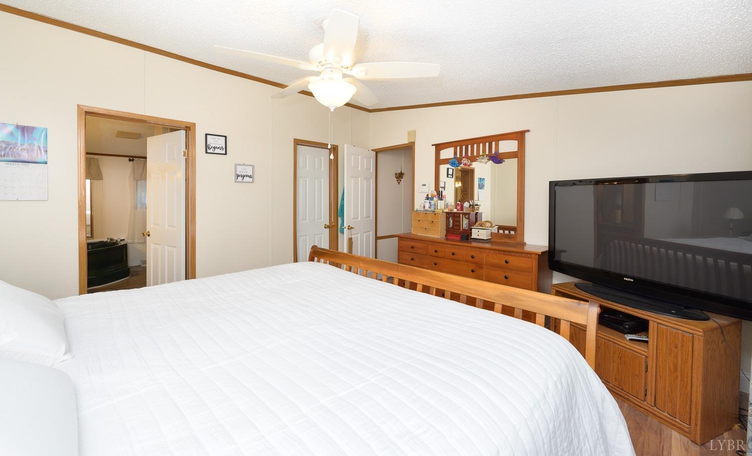 461 Byrd Mill Road Louisa, VA 23093 - Photo 45 of 81 a bedroom with a bed and a flat tv screen on dresser
