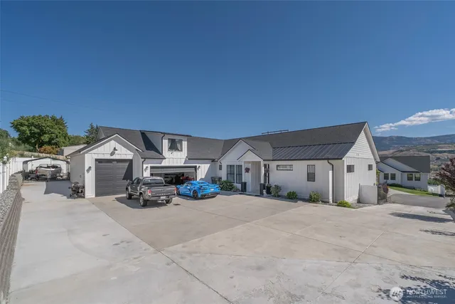 a view of a house with large trees and roof