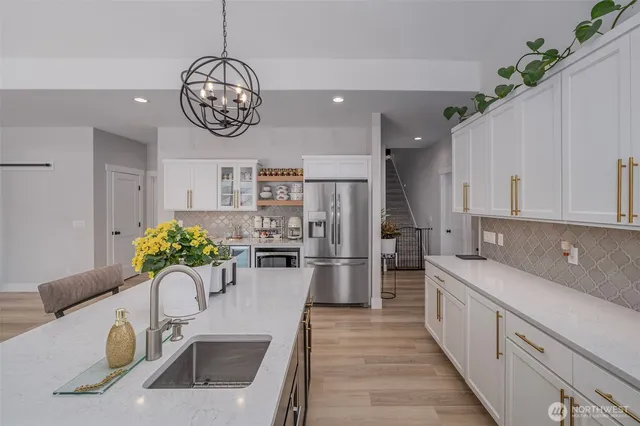 a kitchen with a sink refrigerator and cabinets