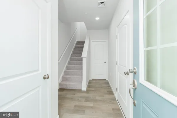 a view of a hallway with wooden floor and entryway