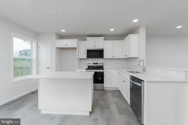 a kitchen with granite countertop white cabinets and black stainless steel appliances