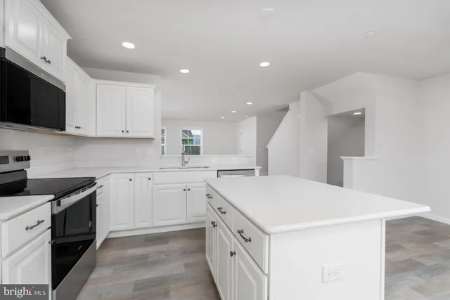a kitchen with white cabinets appliances and sink