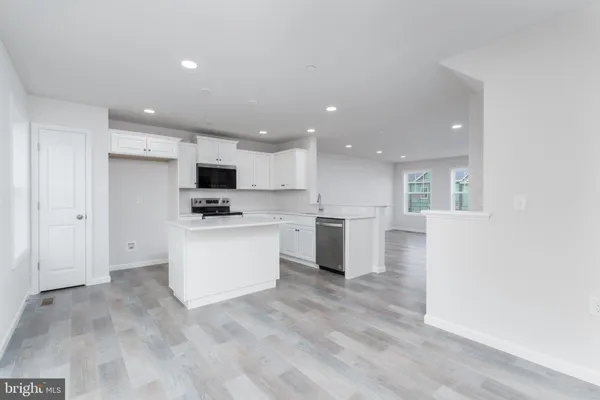 a view of kitchen with granite countertop cabinets and refrigerator