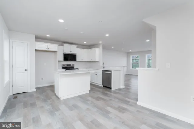 a view of kitchen with granite countertop cabinets and refrigerator