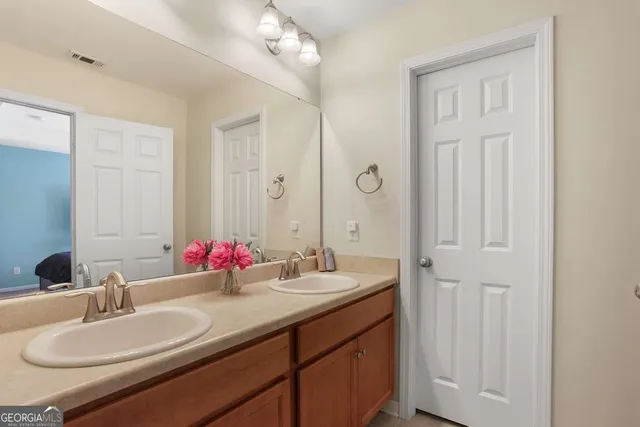 a bathroom with double vanity sinks and a mirror