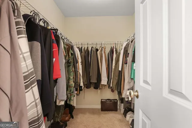 a view of walk in closet with clothes