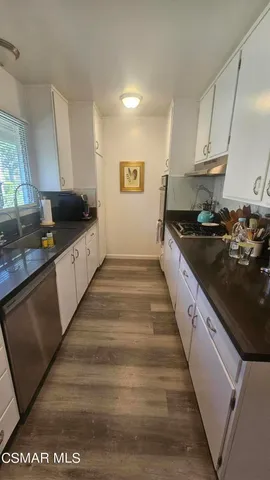 a large kitchen with granite countertop a stove and a sink