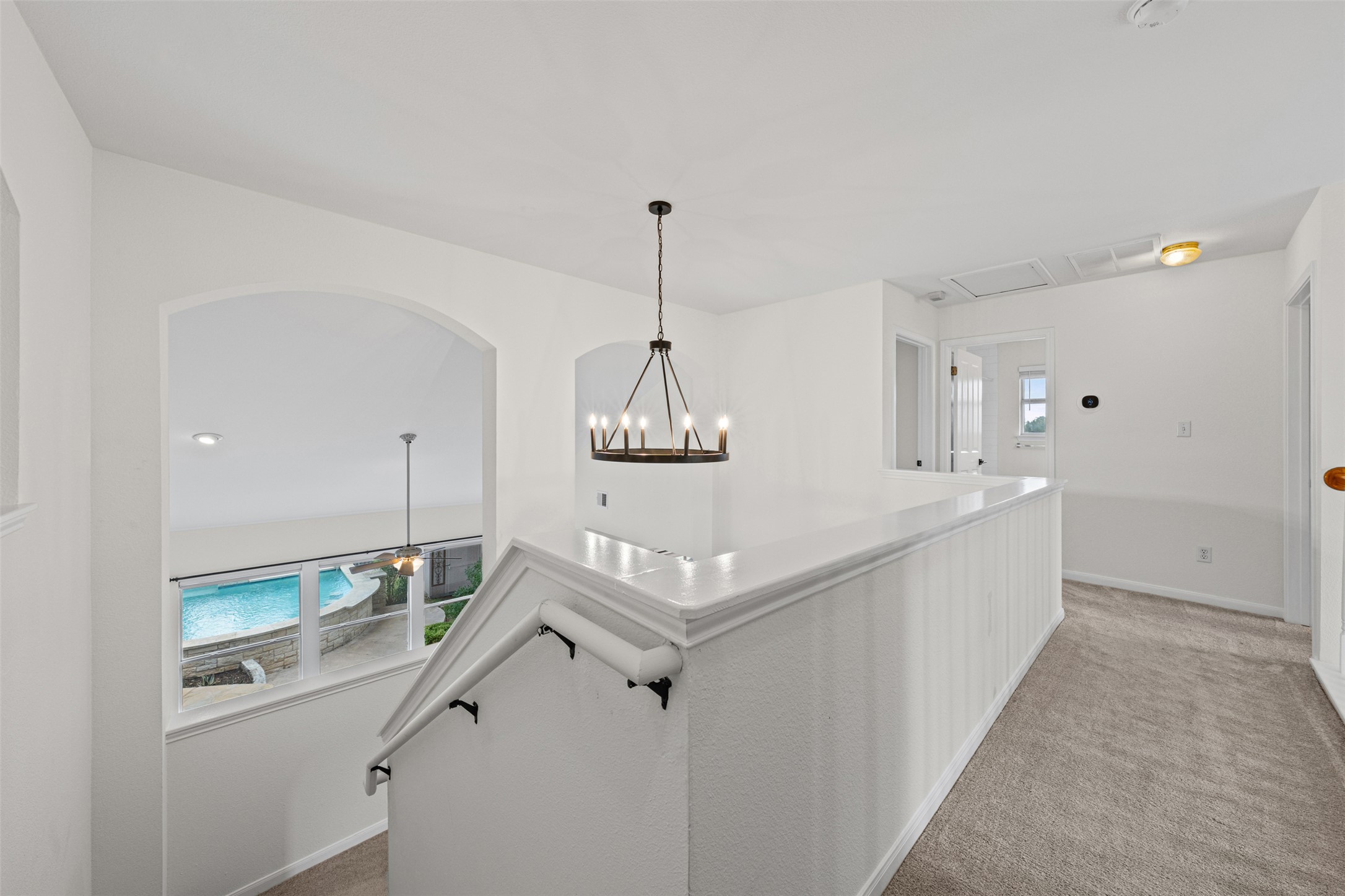 8820 Colberg Drive Austin, TX 78749 - Photo 22 of 35 An inviting upstairs landing features an elegant chandelier and a railing overlooking a refreshing pool.
