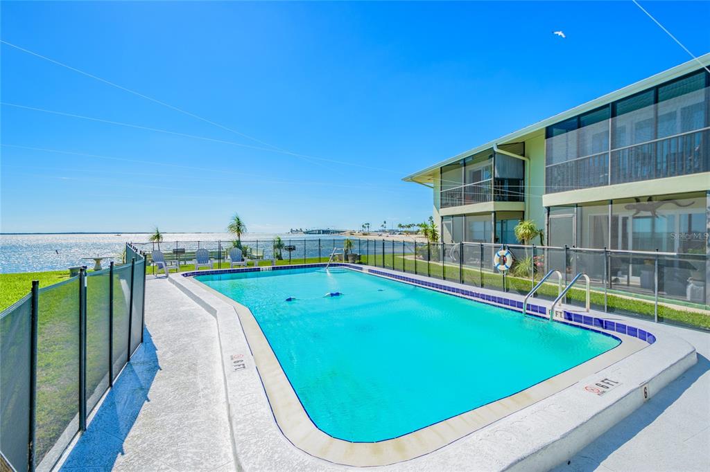 2570 Gary Circle, Unit 4 Dunedin, FL 34698 - Photo 17 of 20 a view of a swimming pool with lawn chairs