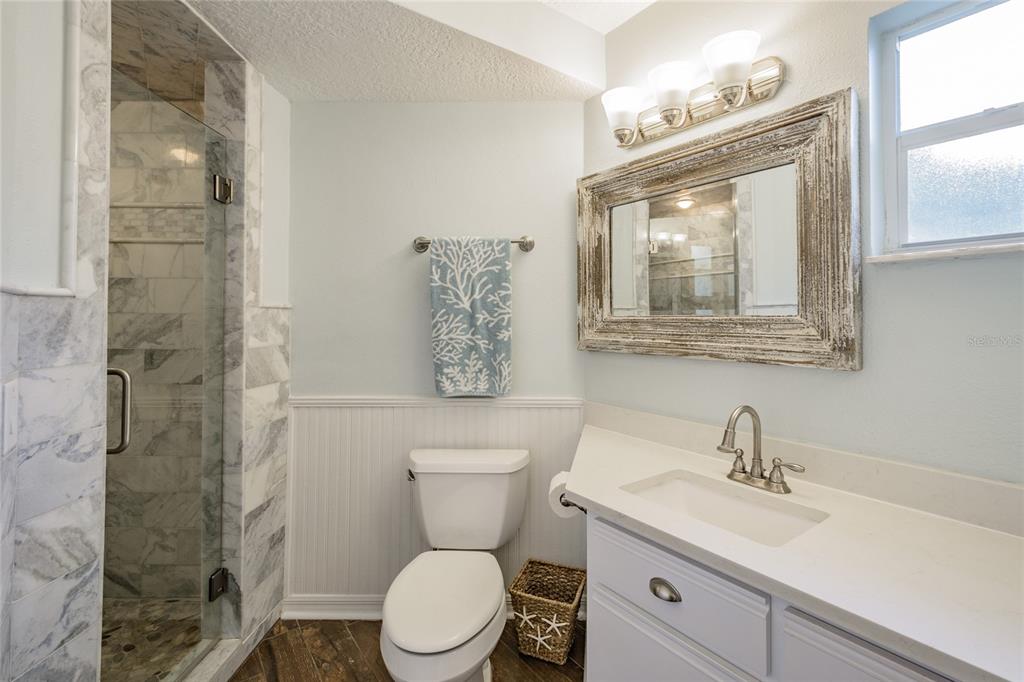 2570 Gary Circle, Unit 4 Dunedin, FL 34698 - Photo 6 of 20 a bathroom with a toilet sink vanity and mirror