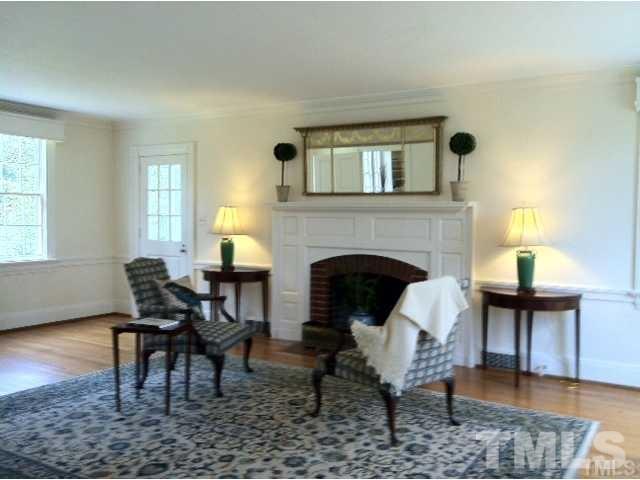 338 Tenney Circle Chapel Hill, NC 27514 - Photo 7 of 25 Living room with wood burning fireplace and original paneling and mantle.