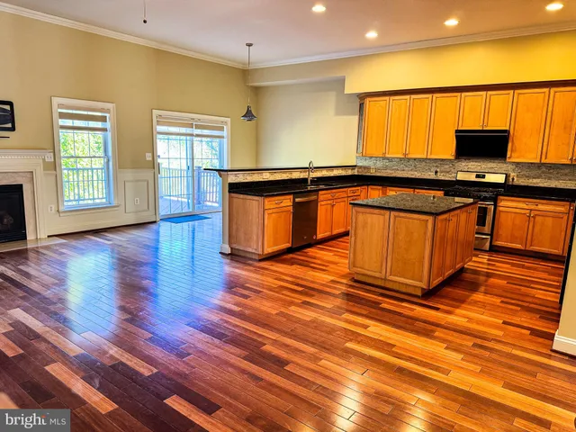 a kitchen with stainless steel appliances granite countertop a stove top oven microwave and cabinets