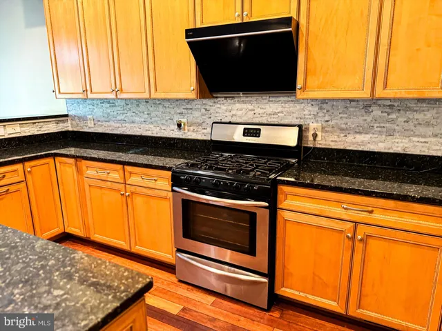 a kitchen with granite countertop wooden floors and a fireplace