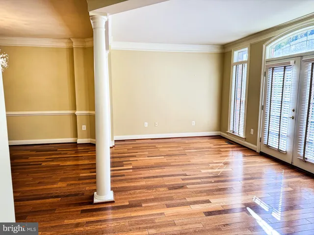 a view of a room with wooden floor and windows