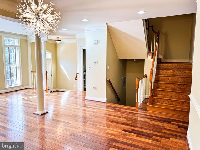 a kitchen with stainless steel appliances granite countertop a sink a stove top oven a refrigerator and island with wooden floor