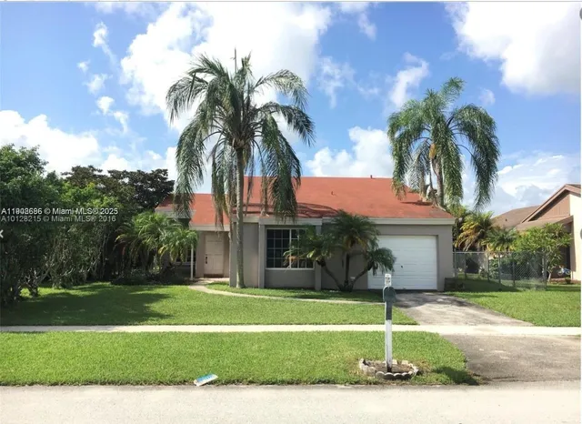 a palm tree sitting in front of a house with a yard