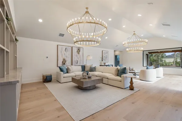 a living room with furniture and a chandelier