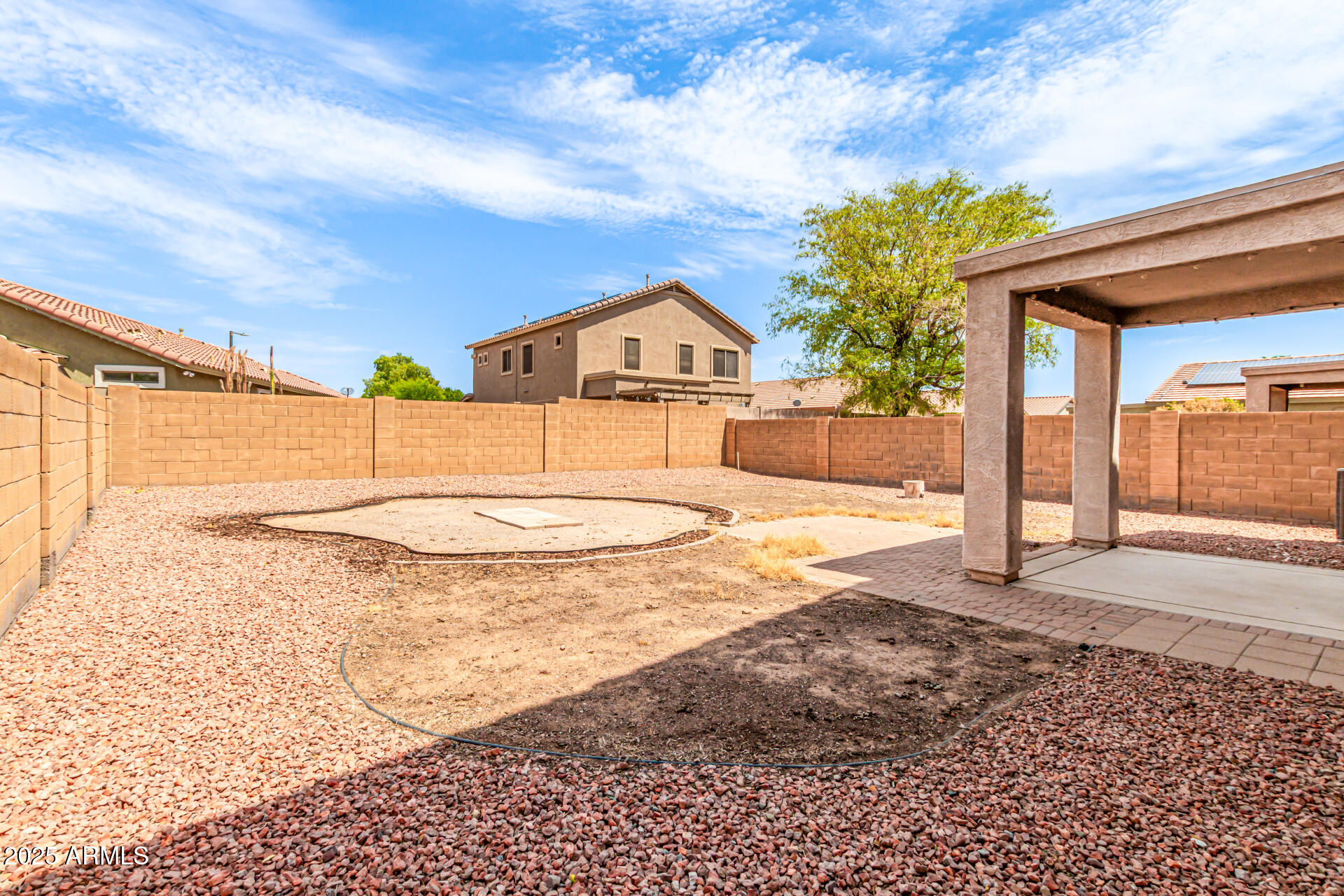 16890 West Rimrock Street Surprise, AZ 85388 - Photo 24 of 28 a view of a white house with a yard and table and chairs under an umbrella