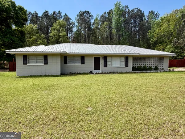 a front view of a house with yard and trees