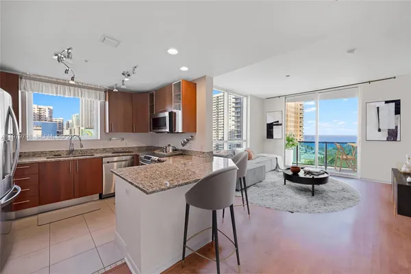 a kitchen with kitchen island granite countertop wooden cabinets a counter top space and stainless steel appliances