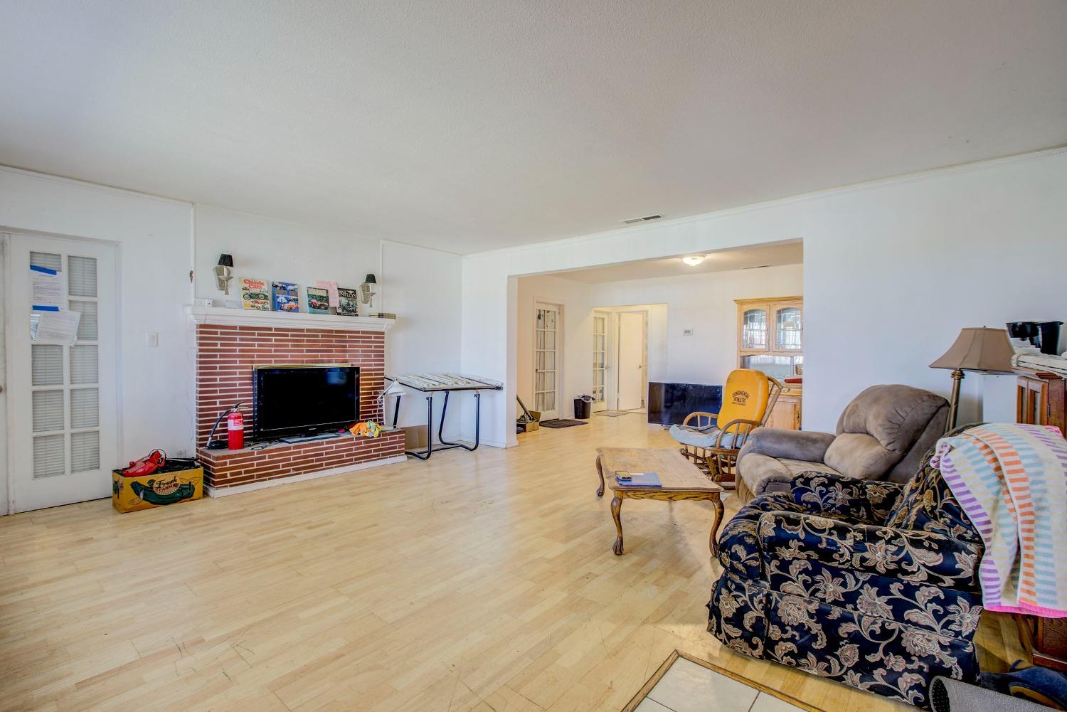 8758 Florin Road Sacramento, CA 95829 - Photo 7 of 14 a living room with furniture a fireplace and a flat screen tv