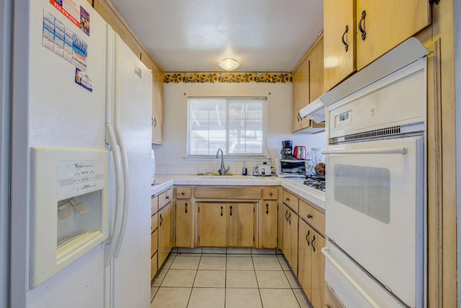8758 Florin Road Sacramento, CA 95829 - Photo 8 of 14 a kitchen with a sink a refrigerator and cabinets