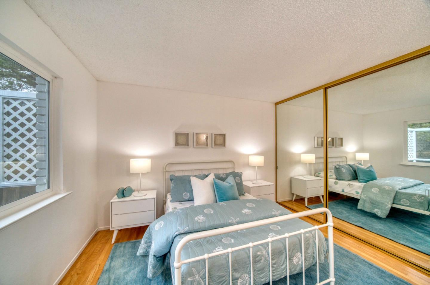 8701 Cabrillo Highway Montara, CA 94037 - Photo 26 of 40 a bedroom with a bed and wooden floor