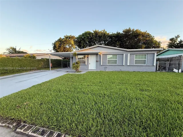 a view of a house with a yard and sitting area