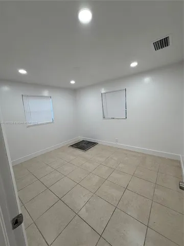 an empty room with white walls and tiles