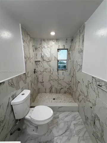 a bathroom with a toilet sink and shower