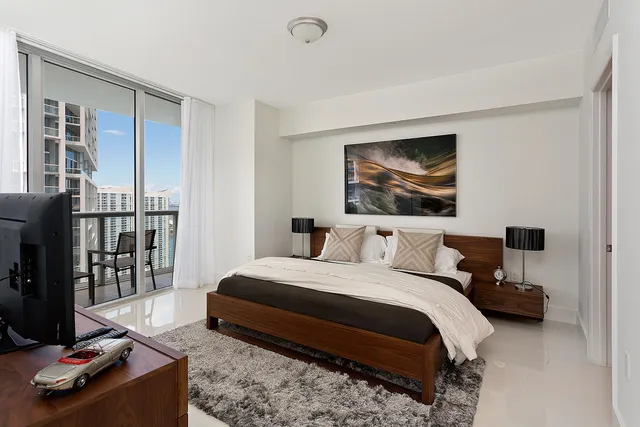 a bedroom with furniture and a flat screen tv