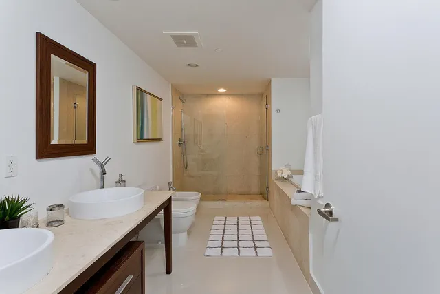 a bedroom with a large bed and a flat tv screen on the dresser