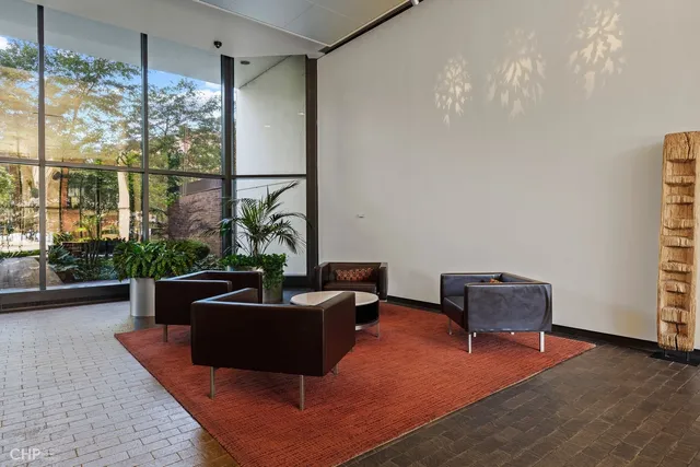 a living room with furniture potted plant floor to ceiling window and potted plant