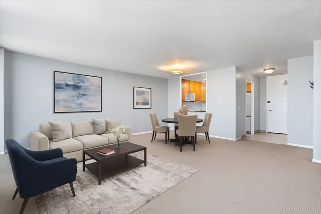 a living room with furniture and a dining table with chair