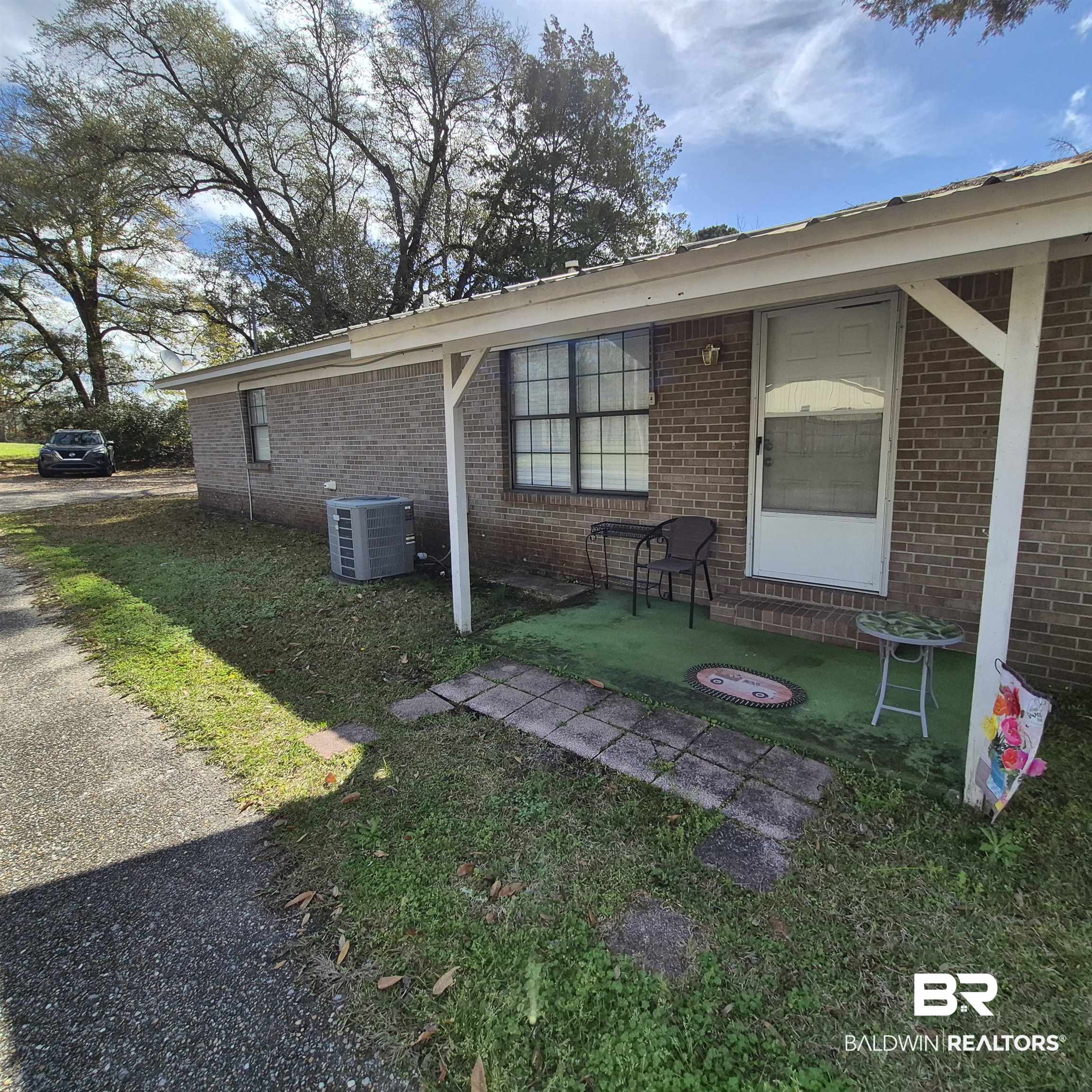 721 Perryman Street Evergreen, AL 36401 - Photo 19 of 26 View of property exterior featuring brick siding and a yard