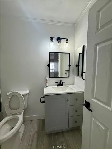 a room with a hardwood floor and a chandelier fan