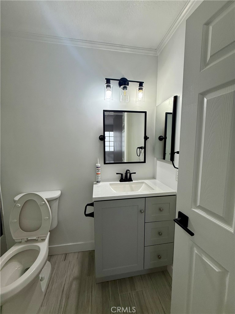 7815 Howe Street, Unit B Paramount, CA 90723 - Photo 16 of 20 a bathroom with a toilet sink and mirror