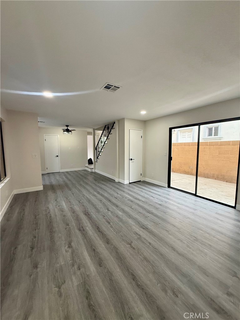 7815 Howe Street, Unit B Paramount, CA 90723 - Photo 4 of 20 a view of an empty room with wooden floor and a window