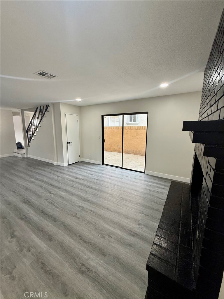 7815 Howe Street, Unit B Paramount, CA 90723 - Photo 6 of 20 an empty room with wooden floor and windows