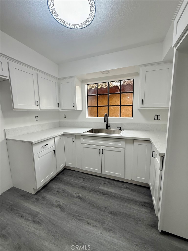 7815 Howe Street, Unit B Paramount, CA 90723 - Photo 7 of 20 a kitchen with a sink cabinets appliances and a window