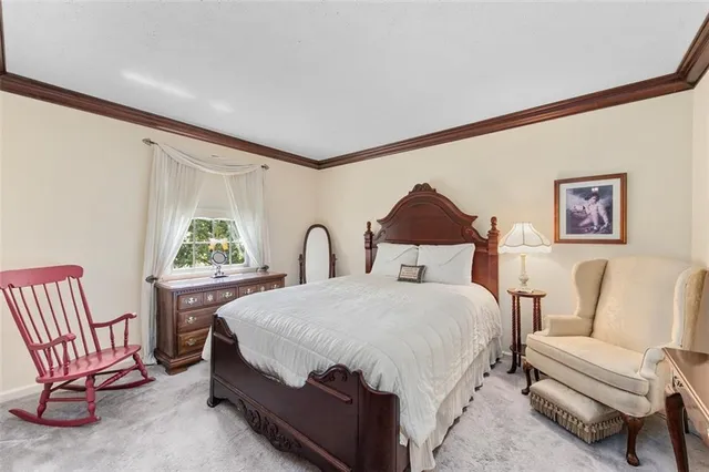 a bedroom with a bed a couch and dresser