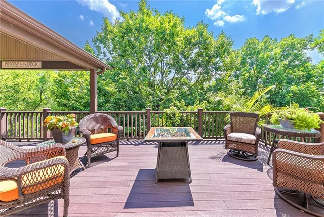 a view of a roof deck with couches chairs and wooden floor