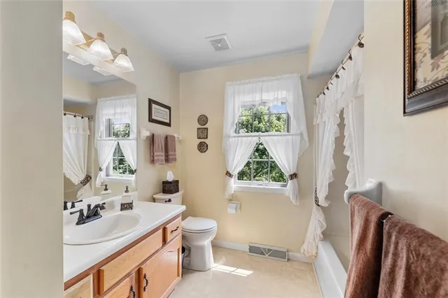 a bathroom with a sink toilet mirror and tub